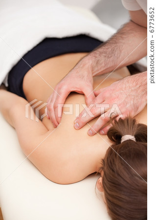 Woman lying on the table while being massaged Woman lying on the table while being massaged 6773652