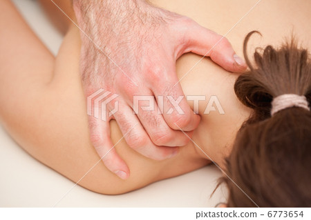 Chiropractor squeezing the shoulder of woman while massaging Chiropractor squeezing the shoulder of woman while massaging 6773654