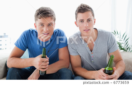 Two guys looking into the camera with beer in hand Two guys looking into the camera with beer in hand 6773659