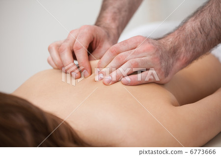 Chiropractor massaging his patient while using his fingertips Chiropractor massaging his patient while using his fingertips 6773666
