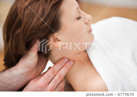 Therapist massaging the neck of woman while holding her head 6773670