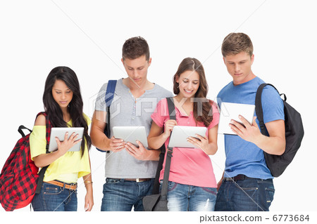 Students with backpacks looking at their tablets Students with backpacks looking at their tablets 6773684