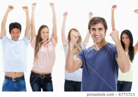 Man clenching his fists with people behind him raising their arm Man clenching his fists with people behind him raising their arm 6773723
