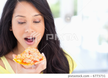 A woman about to eat a slice of pizza 6773731