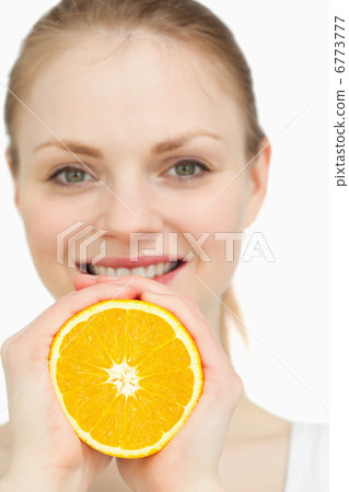 Close up of a woman squeezing an orange between her hands Close up of a woman squeezing an orange between her hands 6773777