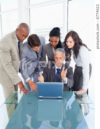 Mature and serious manager giving explanations to his team with 6774022