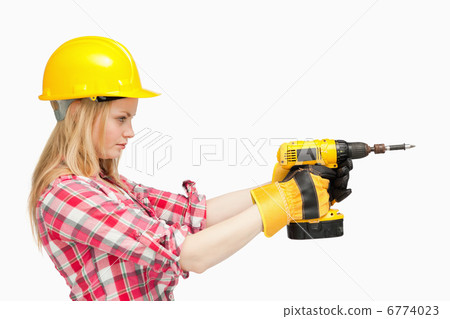 Serious woman using an electric screwdriver Serious woman using an electric screwdriver 6774023