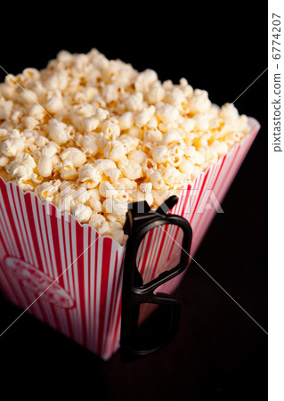 3D glasses hanging on the corner of a box of popcorn 3D glasses hanging on the corner of a box of popcorn 6774207