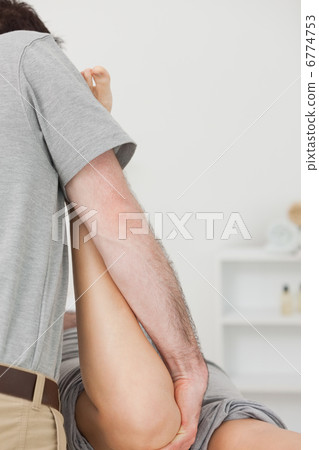 Physiotherapist manipulating the leg of a patient Physiotherapist manipulating the leg of a patient 6774753