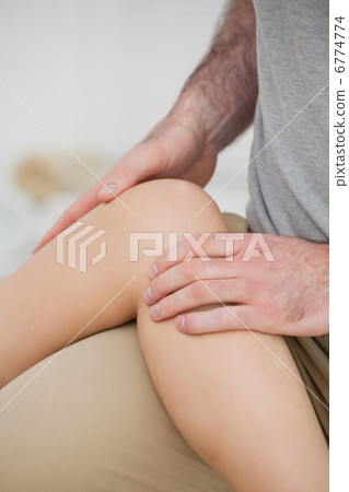 Physiotherapist folding a leg over her thigh Physiotherapist folding a leg over her thigh 6774774