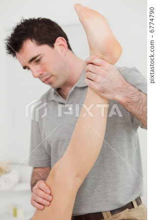Chiropractor extending the leg of a patient Chiropractor extending the leg of a patient 6774790