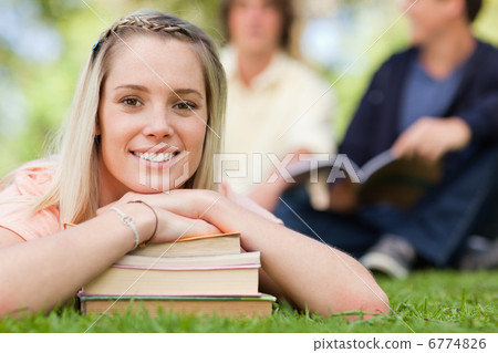 Portrait of a girl lying head on her books Portrait of a girl lying head on her books 6774826
