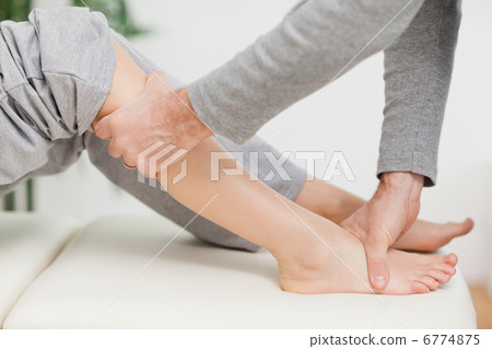 Doctor making joint mobilisation with the knee of a patient Doctor making joint mobilisation with the knee of a patient 6774875