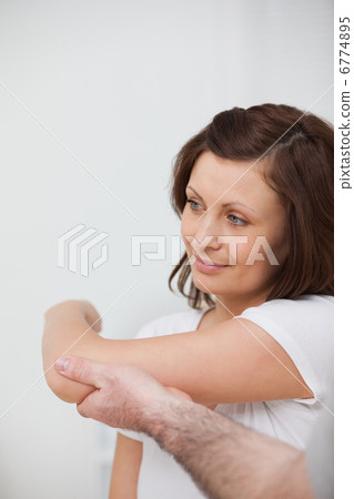 Smiling woman being stretched by a man Smiling woman being stretched by a man 6774895