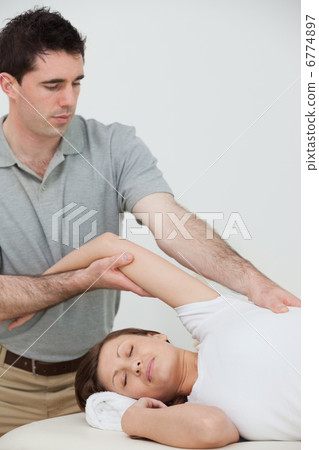relaxed woman being stretched by a physiotherapist 6774897