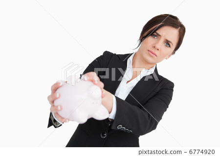 Upset businesswoman holding an empty piggy bank Upset businesswoman holding an empty piggy bank 6774920