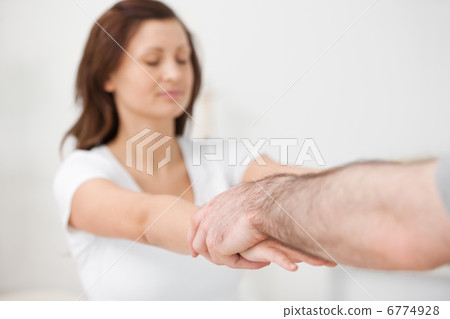 Practitioner extending the arms of a patient Practitioner extending the arms of a patient 6774928