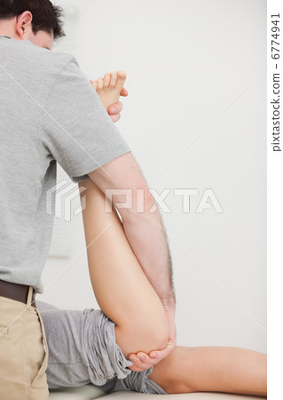 Woman lying forward while being manipulated by a doctor Woman lying forward while being manipulated by a doctor 6774941