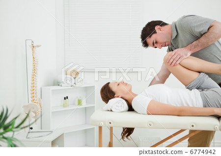 Brunette woman being stretched while she is lying Brunette woman being stretched while she is lying 6774942