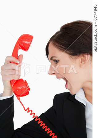 Woman in suit screaming on a red dial telephone 6774946