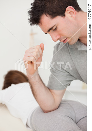 Physiotherapist massaging a patient with his elbow Physiotherapist massaging a patient with his elbow 6774947
