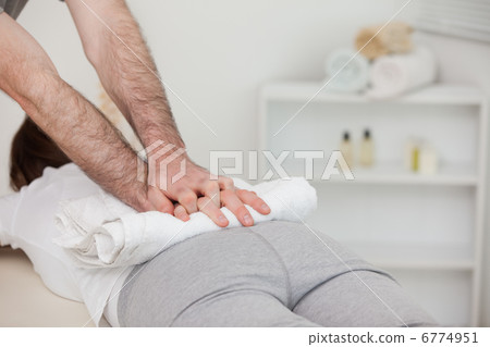 Masseur massaging a woman with a towel Masseur massaging a woman with a towel 6774951