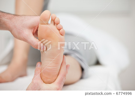 Doctor holding the foot of a woman Doctor holding the foot of a woman 6774996