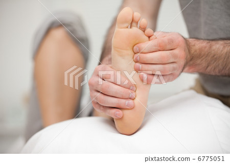 Chiropodist palpating the sole of the foot of a patient 6775051