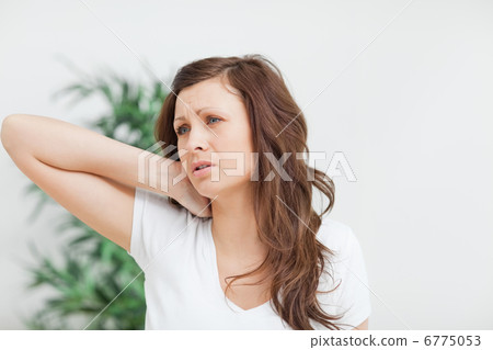 Woman placing her hand on her neck Woman placing her hand on her neck 6775053
