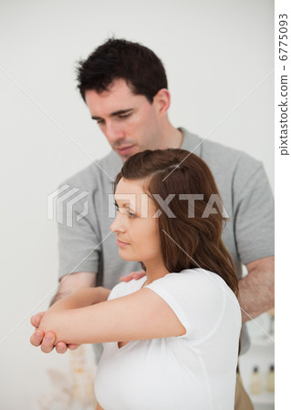 Serious doctor stretching the arm of a patient Serious doctor stretching the arm of a patient 6775093