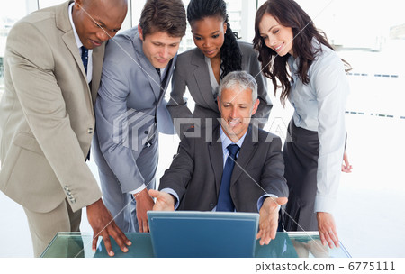 Mature manager sitting at the desk surrounded by his serious tea 6775111