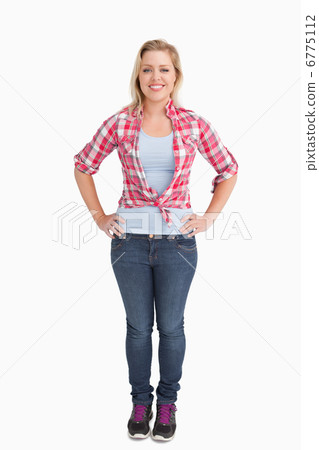 Happy young woman placing her hand on her hips 6775112