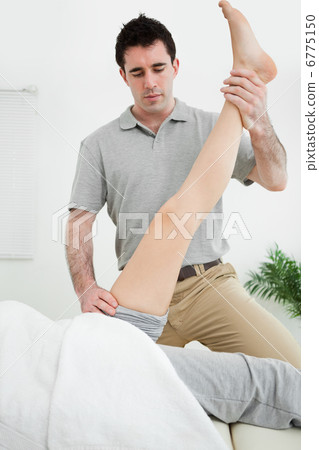 Physiotherapist raising the leg of a patient Physiotherapist raising the leg of a patient 6775150