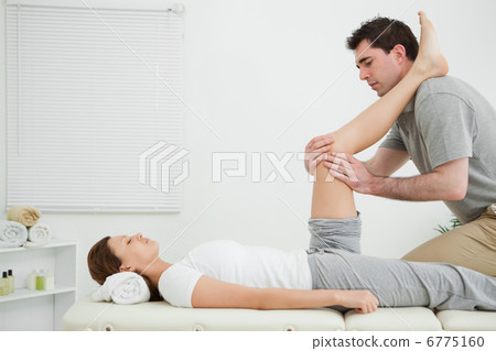 Man massaging a knee while placed it on his shoulder Man massaging a knee while placed it on his shoulder 6775160