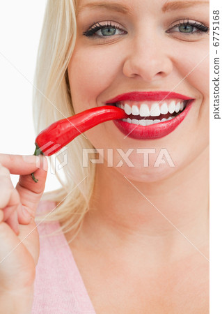 Cheerful blonde woman eating a chili Cheerful blonde woman eating a chili 6775168