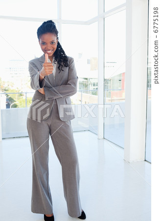 Secretary standing upright with her thumbs up in approval Secretary standing upright with her thumbs up in approval 6775198