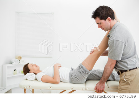Man massaging a leg while placing it on his shoulder Man massaging a leg while placing it on his shoulder 6775199