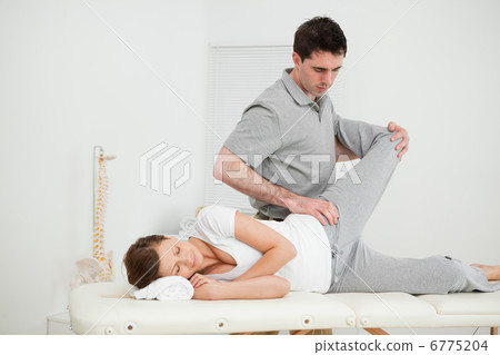 Serious osteopath making joint mobilisation Serious osteopath making joint mobilisation 6775204