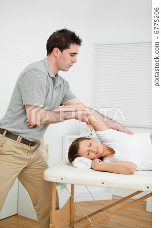 Serious doctor making a manual stretching Serious doctor making a manual stretching 6775206