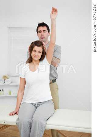 Peaceful woman raising her arm while being manipulated Peaceful woman raising her arm while being manipulated 6775218