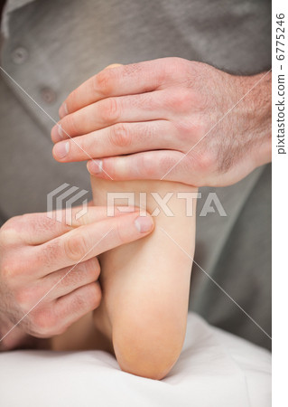 Two fingers pressing the sole of a foot 6775246