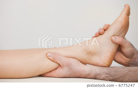 Chiropodist holding the ankle of a patient 6775247