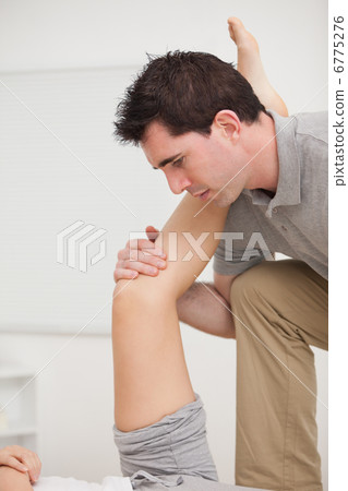 Serious osteopath holding a leg Serious osteopath holding a leg 6775276