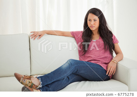 Latino young woman sitting on a sofa Latino young woman sitting on a sofa 6775278