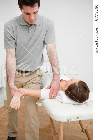 Serious practitioner holding the arm of a woman Serious practitioner holding the arm of a woman 6775280