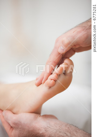 Physiotherapist offering a foot massage Physiotherapist offering a foot massage 6775281