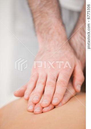 Osteopath massaging his patient while pressing his back Osteopath massaging his patient while pressing his back 6775306