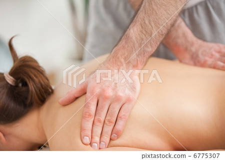 Woman lying on the belly while being massaged on his back Woman lying on the belly while being massaged on his back 6775307