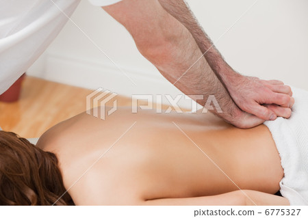 Therapist massaging the back of his patient while standing Therapist massaging the back of his patient while standing 6775327
