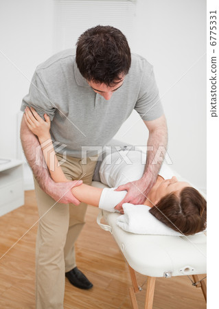Osteopath working on a shoulder of a patient Osteopath working on a shoulder of a patient 6775331